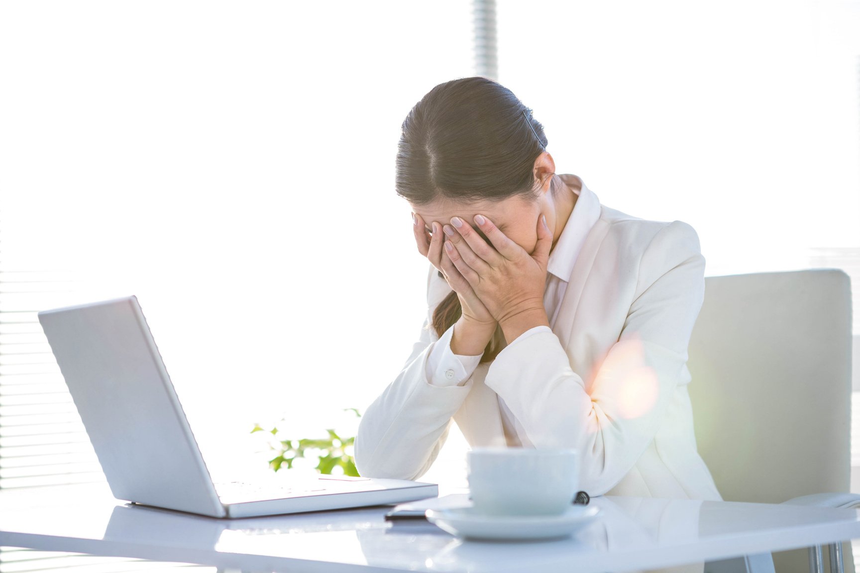 Worried businesswoman covering face